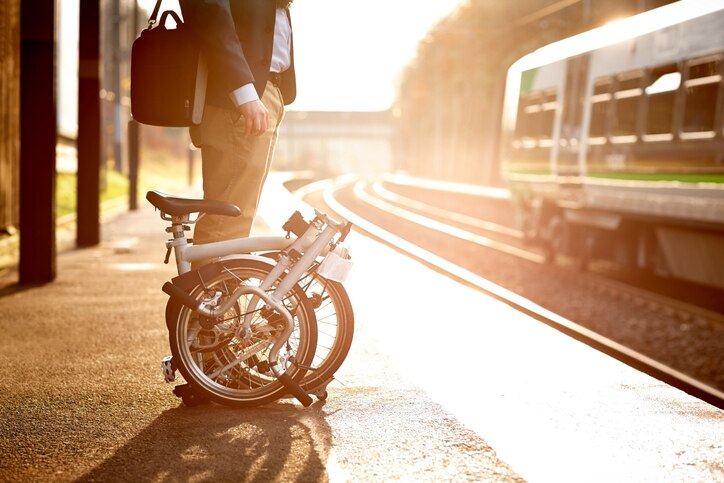 A man with bicycle waiting on a train station platform