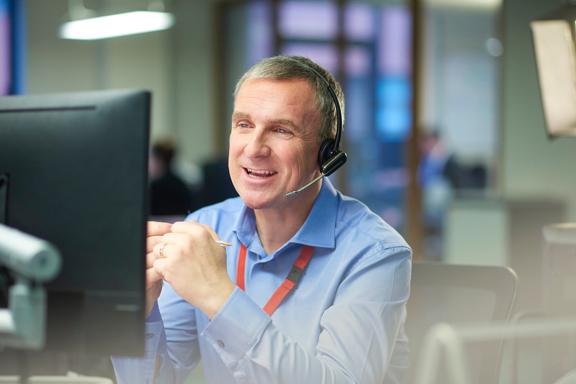 Man sat at a desk wearing a telephone headset