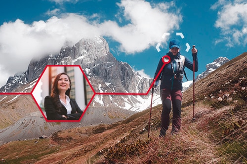A woman is hiking in the mountains. She can also be seen in a smaller picture in a business environment.
