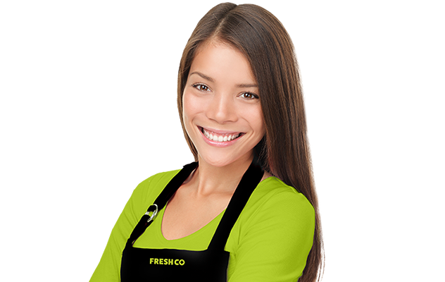 Female FreshCo cashier wearing an apron and smiling