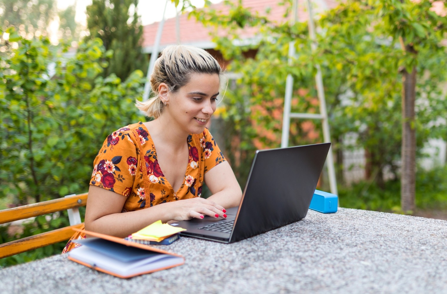 Woman sitting outside working on laptop