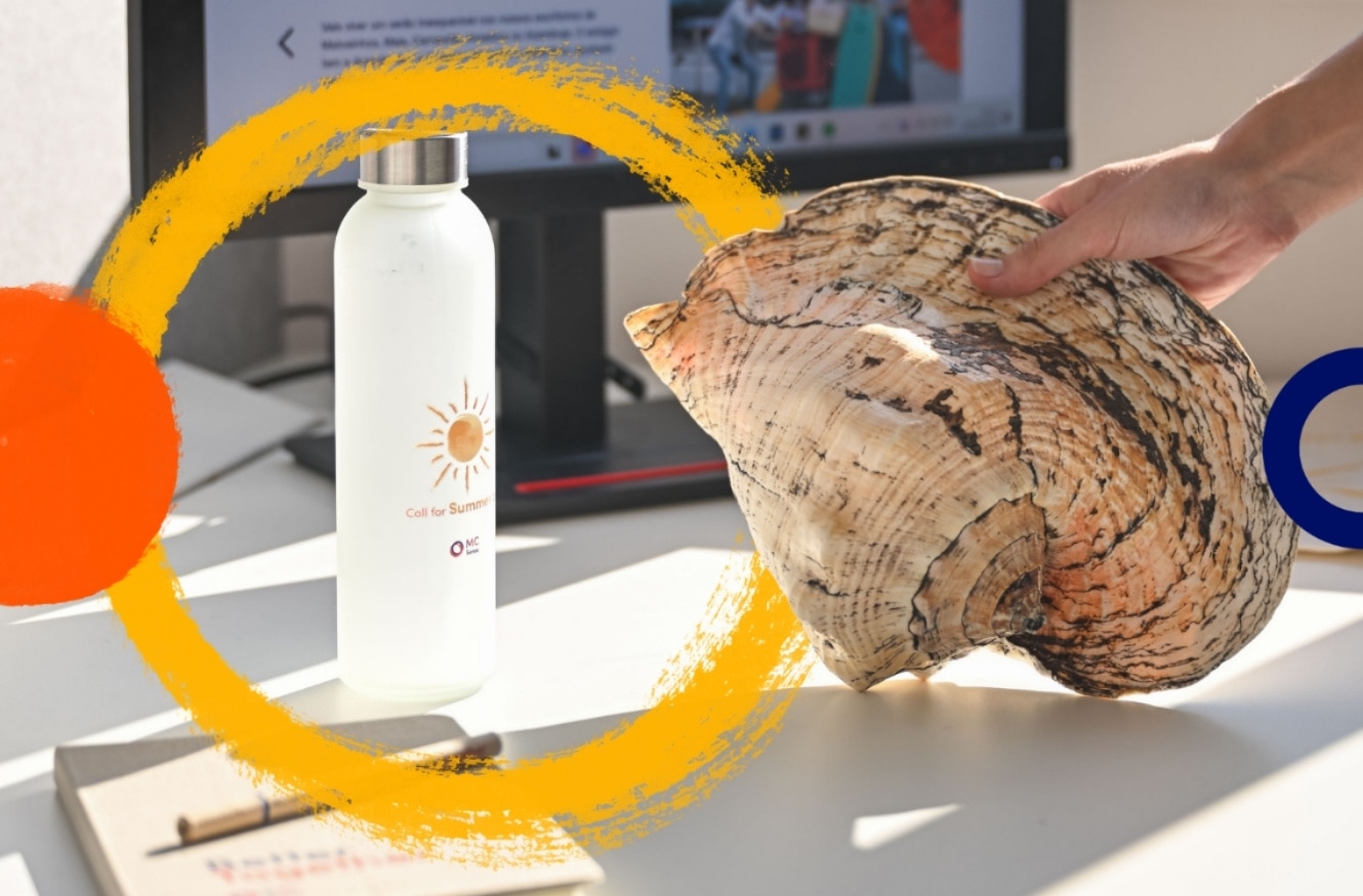 Imagem de um ambiente de trabalho com uma secretária branca. Em primeiro plano, vê‑se uma garrafa reutilizável branca com um ícone de sol e o texto “Call for Summer”, ao lado de uma mão a segurar uma grande concha natural. Ao fundo, aparece um monitor de computador desfocado. Sobre a imagem surgem elementos gráficos decorativos em tons de laranja e amarelo.