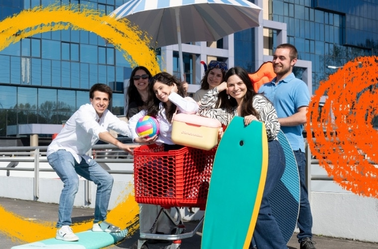 Um grupo de pessoas está reunido ao redor de um carrinho de compras vermelho cheio de itens de praia, incluindo uma bola de vôlei e uma prancha de bodyboard. O grupo está ao ar livre, em frente a um edifício moderno da MC Sonae. Há pinceladas abstratas coloridas em laranja e amarelo sobre partes da imagem. A imagem promove o programa de estágios de Verão Call For Summer.