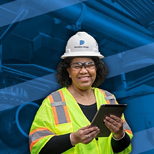 A woman holding a tablet working in personal protective gear