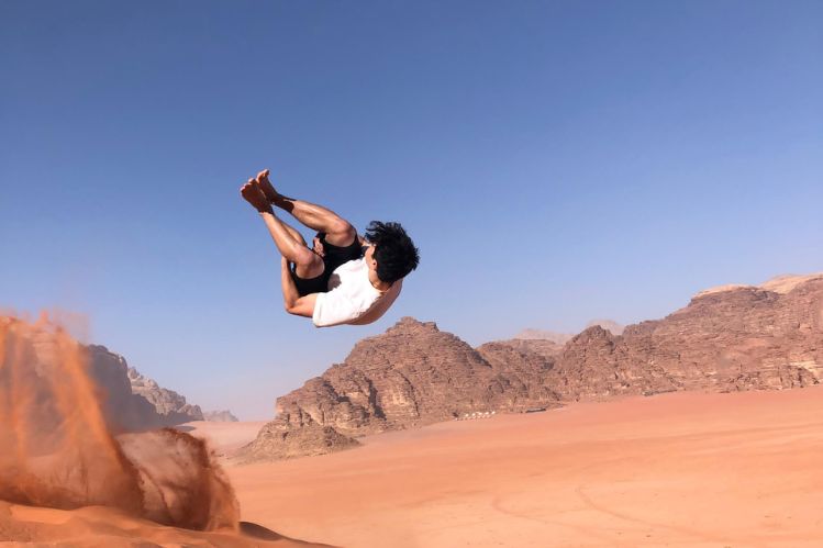 Daniel jumping of sand dune in Jordan