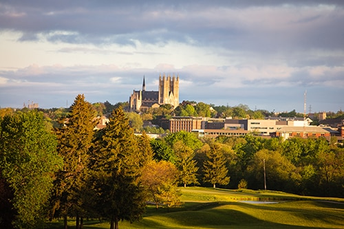 Landscape view of the City of Guelph, featuring buildings and lush greenery.