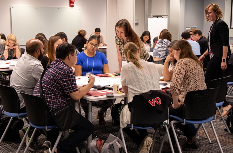 University of Guelph students sitting around a table in groups within a study environment.