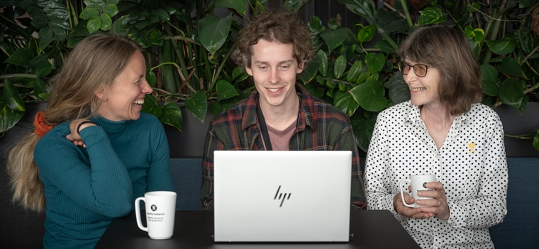 Tre kollegaer samlet rundt en PC i en sosial sone. Foto: Statsforvalteren/Torbjørn Tandberg.