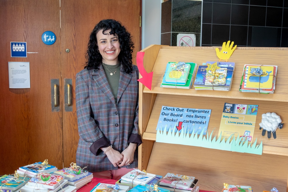 Woman at the library standing next to book bundles for kids