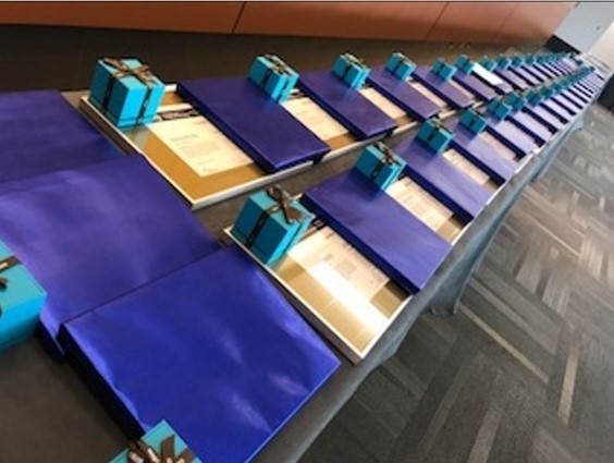 Image of presents and service awards on a long table across a room