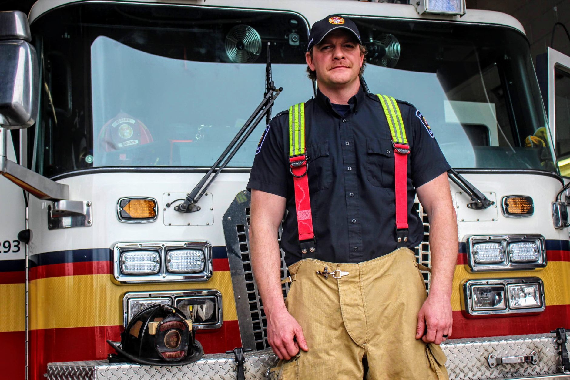 Image of man firefighter in front of fire truck