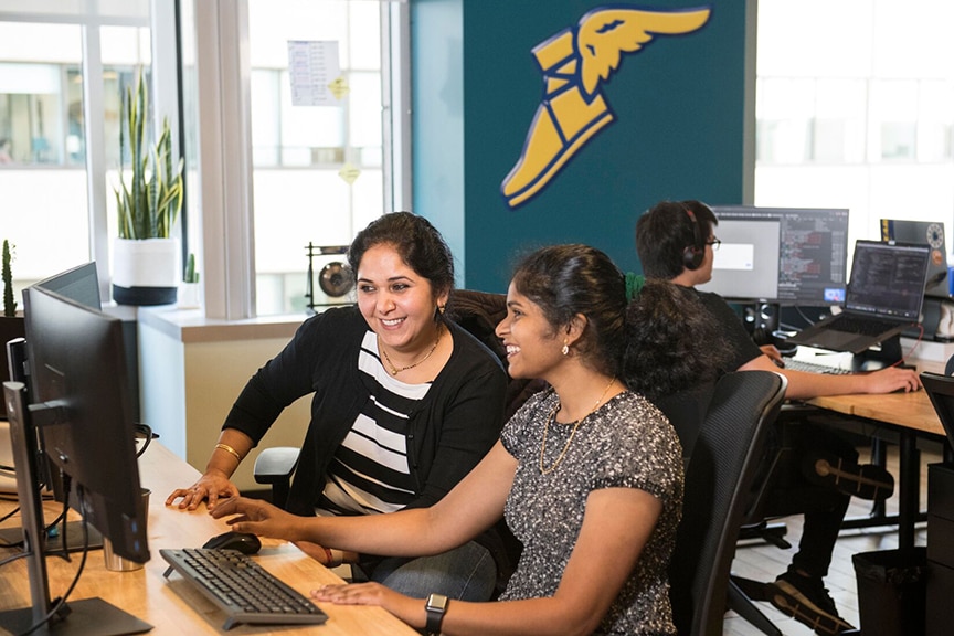 Two Goodyear associates view computer screen