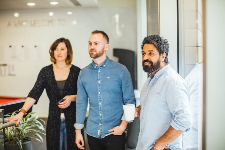 Three members of staff standing together in the office