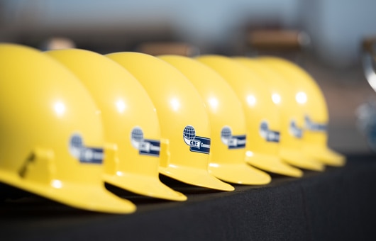 Yellow CMC hardhats arranged on a table