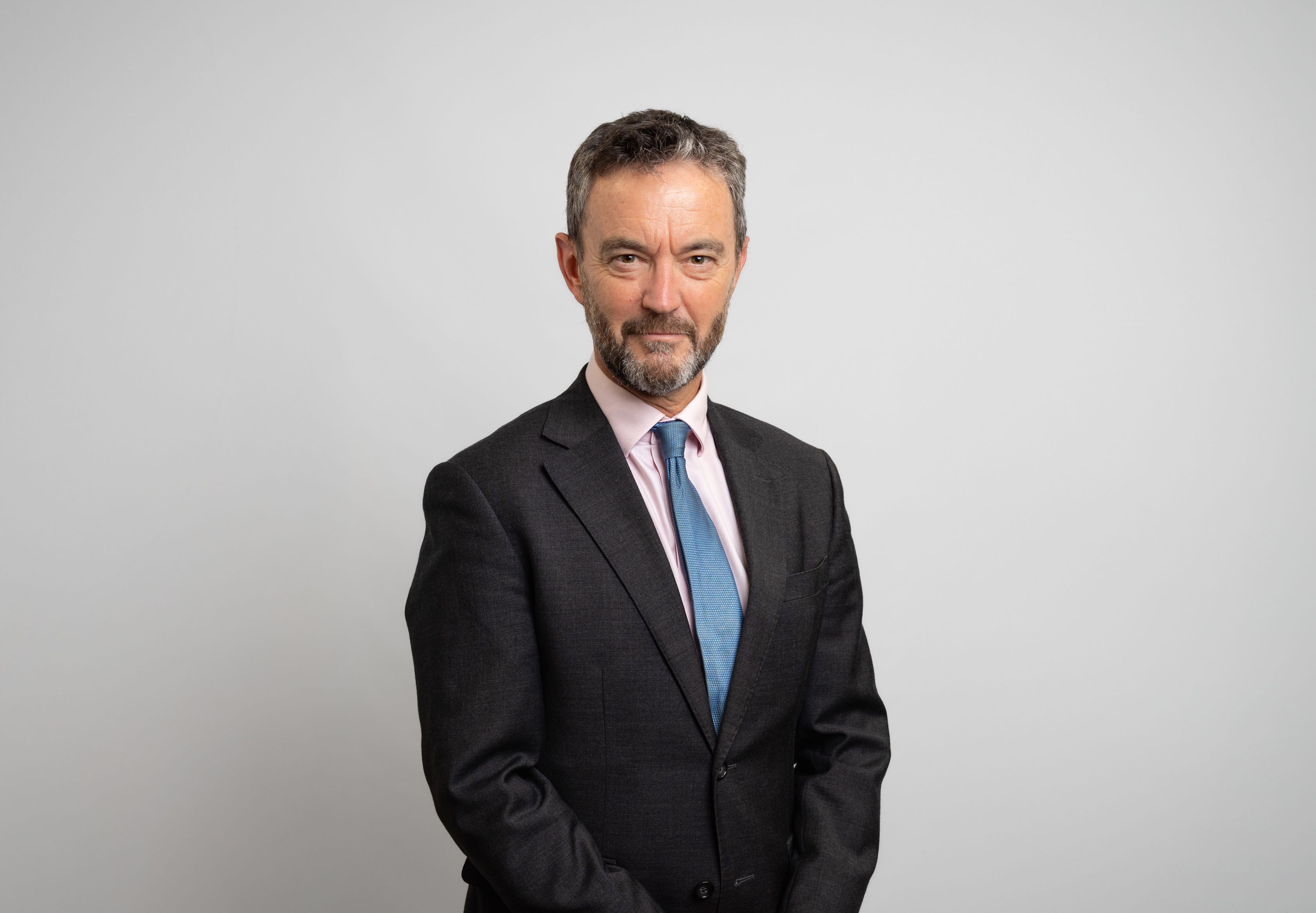 Matthew Jowitt. Matthew is wearing a dark suit, with a pint shirt and blue tie.