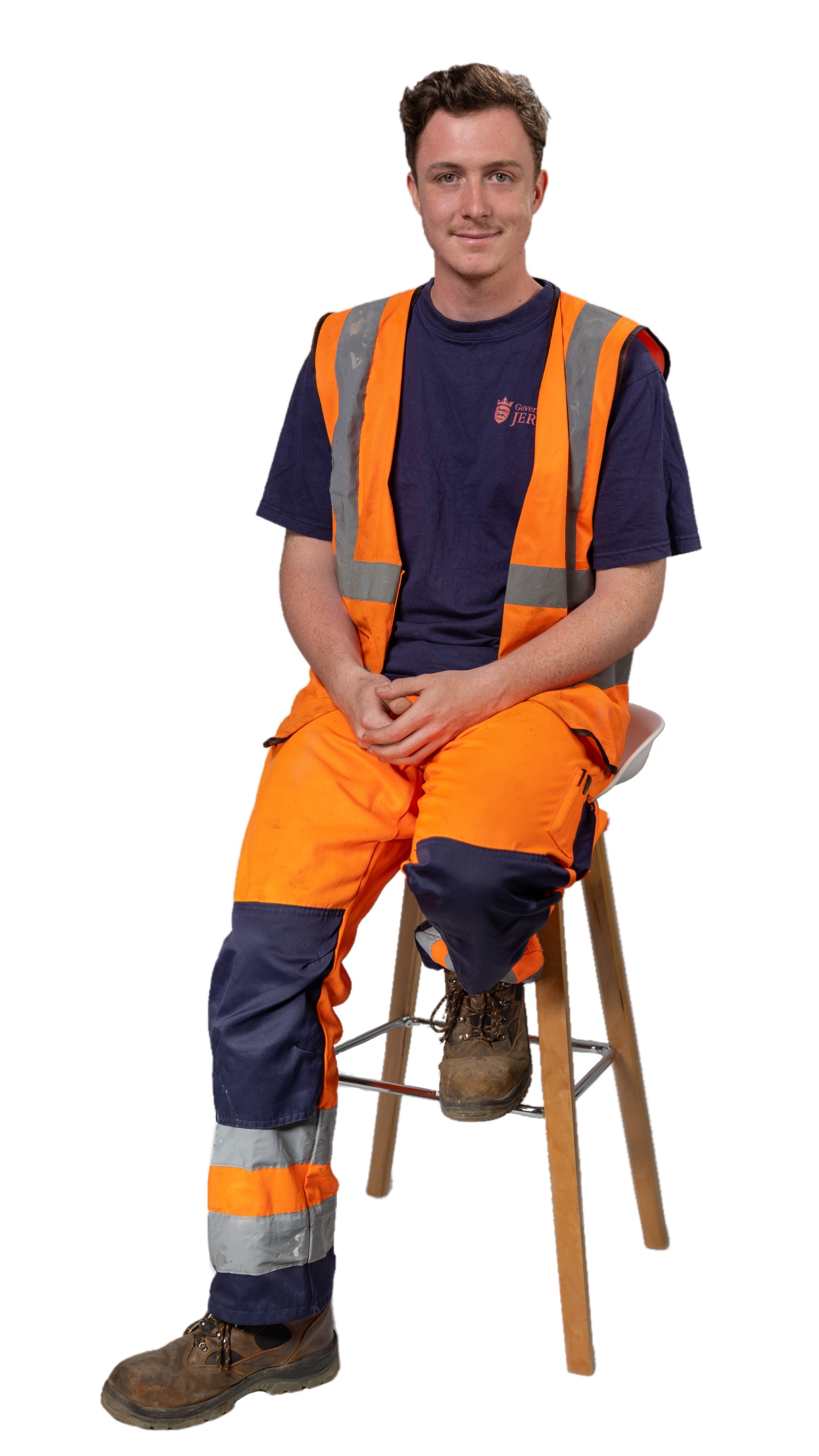 A man in high-visibility orange workwear sits on a chair, representing traineeships in construction or manual labour.