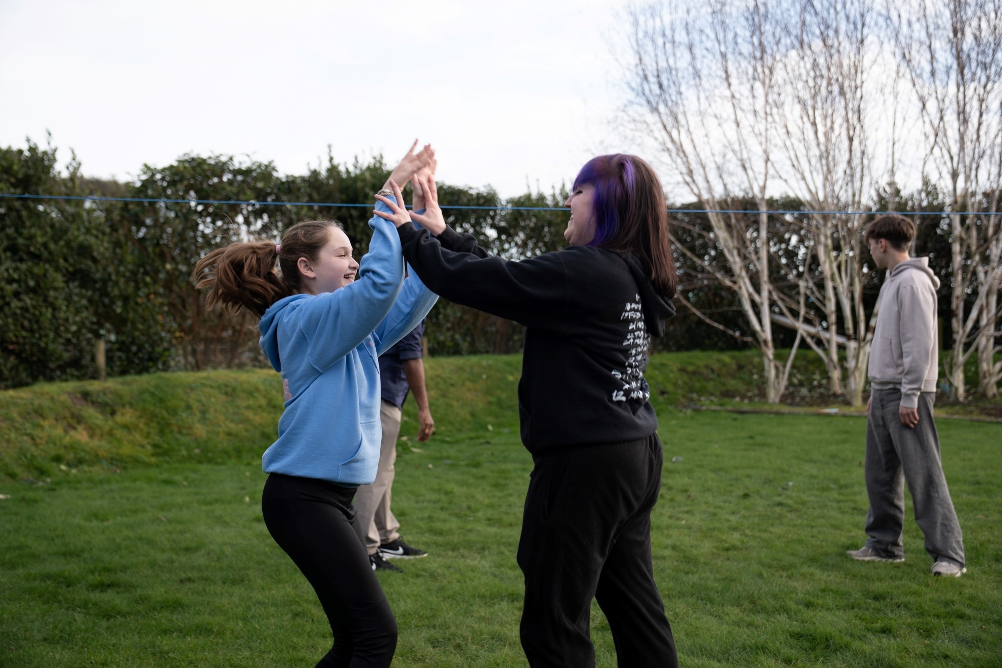 Two people taking part in an outdoor activity in a grassy area.