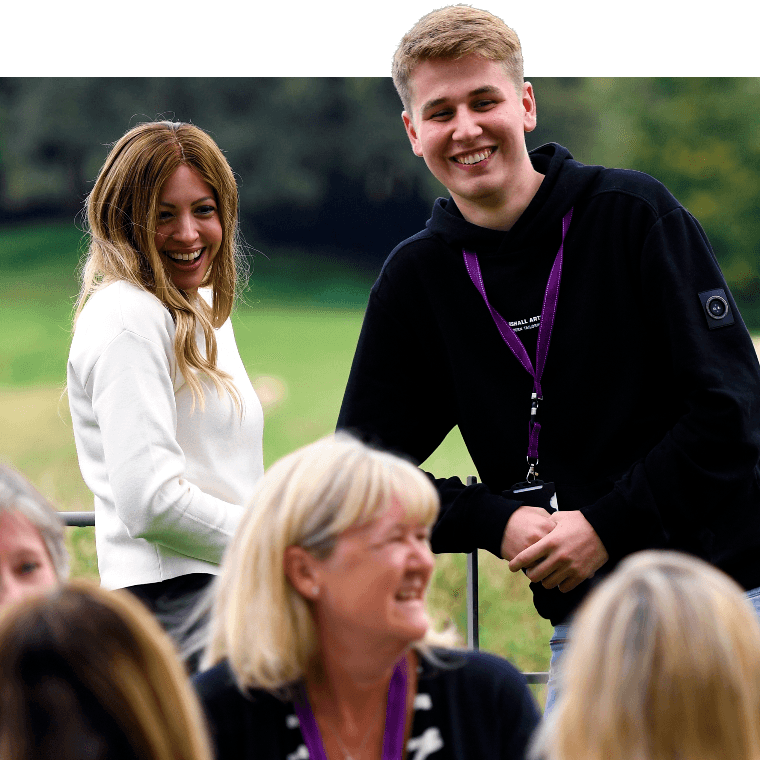 Colleagues talking and smiling outdoors.