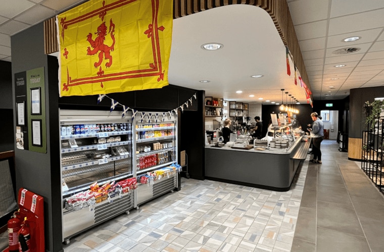 A restaurant with a serving counter and food fridges.