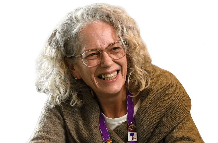A colleague smiling over a table with hot drinks.