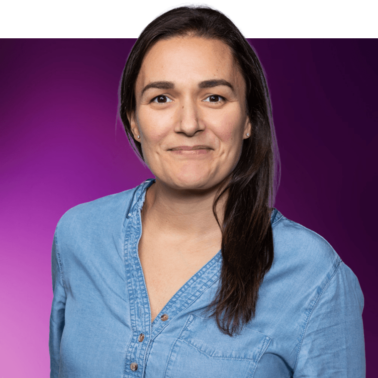 A colleague with dark coloured hair wearing a blue denim shirt, they are smiling.