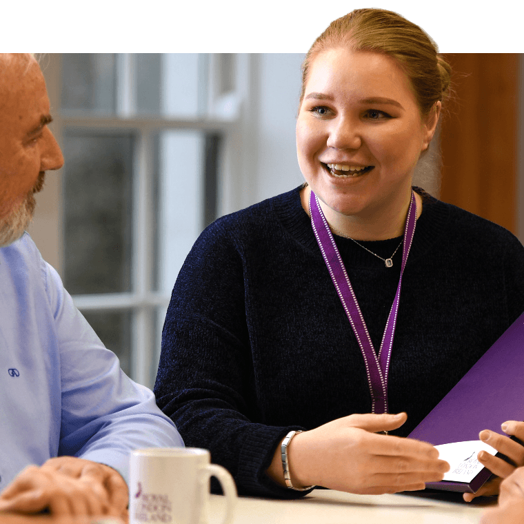 A colleague holding a leaflet and talking.