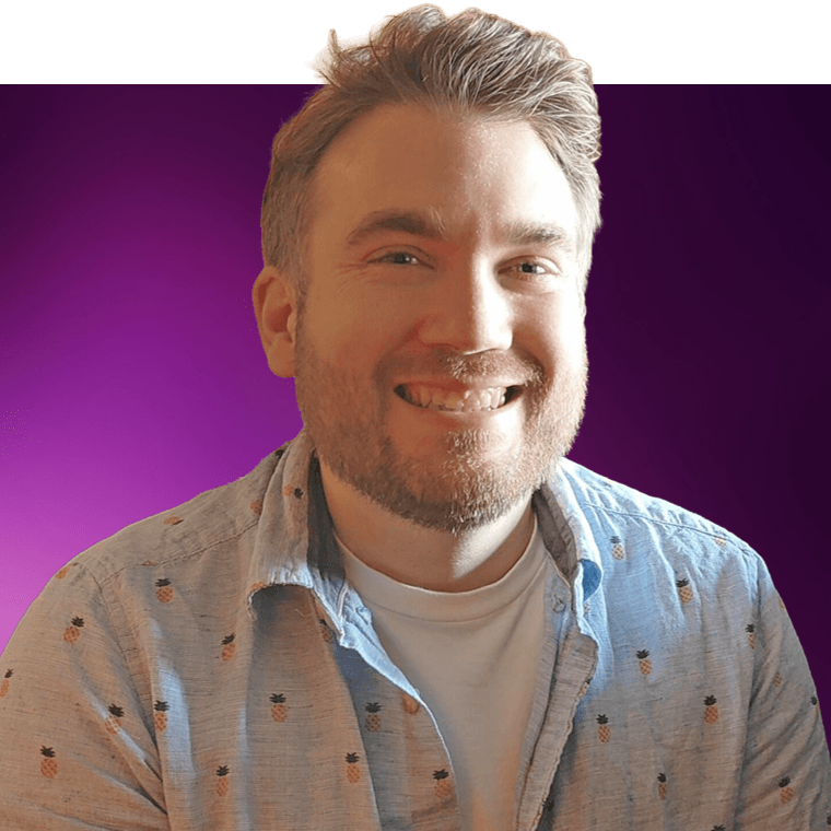 A colleague with light coloured hair wearing a light blue shirt over a white t-shirt, smiling.