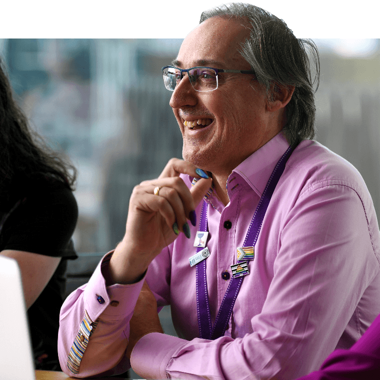 A colleague smiling with rainbow painted nails.