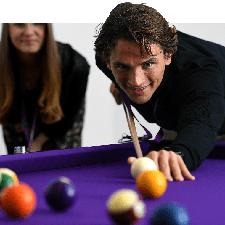Colleagues playing a game of pool.