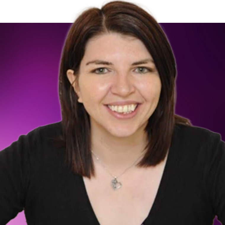 A colleague with brown coloured hair wearing a black top and a silver necklace, they are smiling.