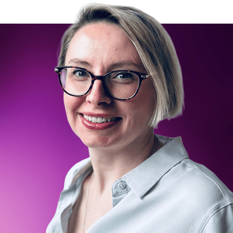 A colleague with light coloured hair wearing glassed, smiling.