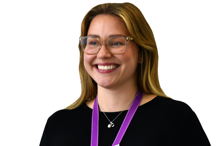 A colleague with light coloured hair and clear frames glasses, wearing a purple lanyard and black top smiling while looking away from the camera.