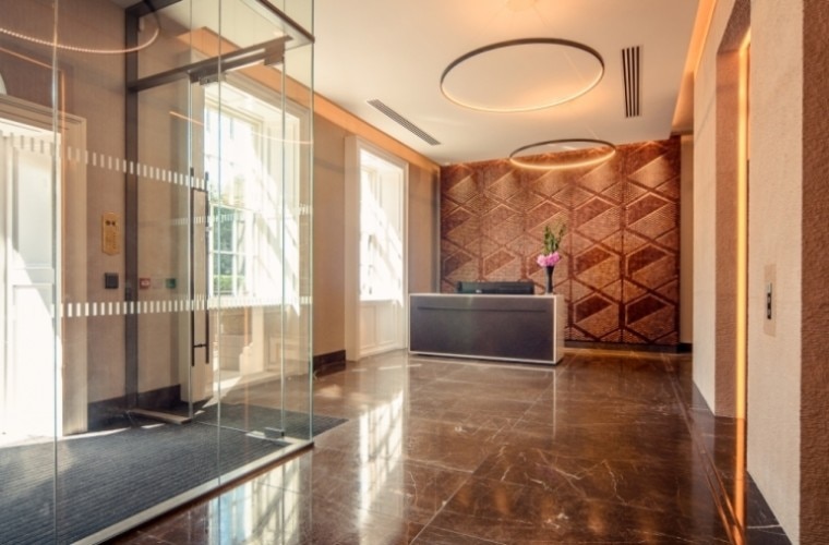 A reception area with brown marble flooring.