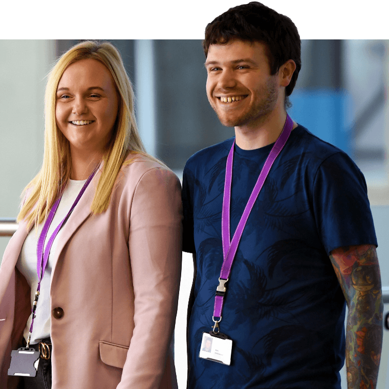 Two colleagues walking together and smiling.