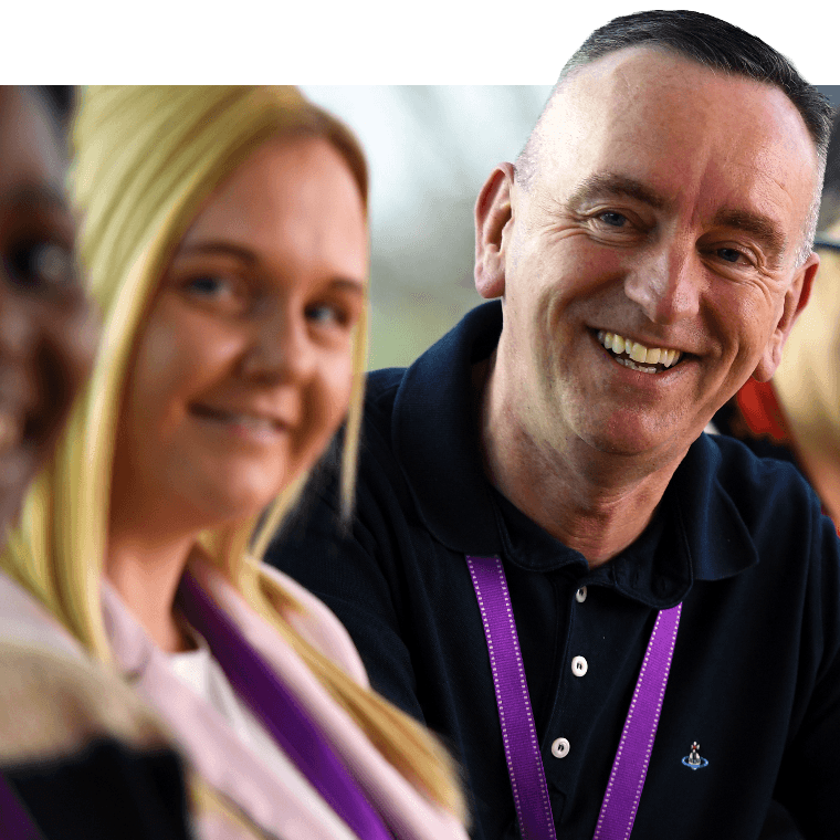 Colleagues talking and smiling between themselves in a meeting.
