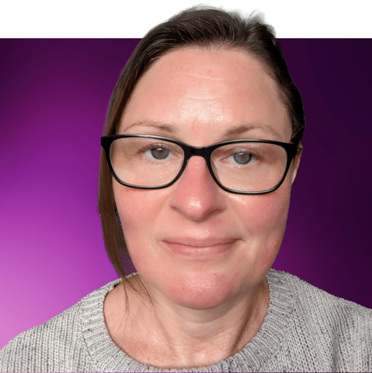 A colleague with dark brown hair wearing black rimmed glasses and a grey knitted jumper.