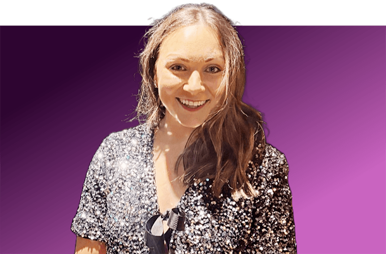 A woman in front of a purple background smiling.