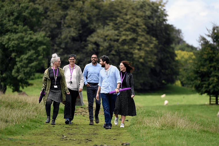 People walking through a green field.