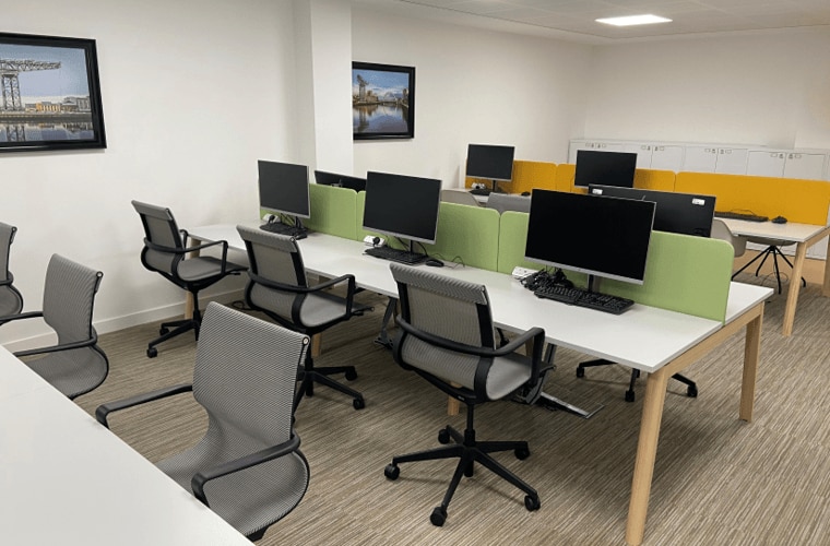An office with desks and chairs and photos on the wall.