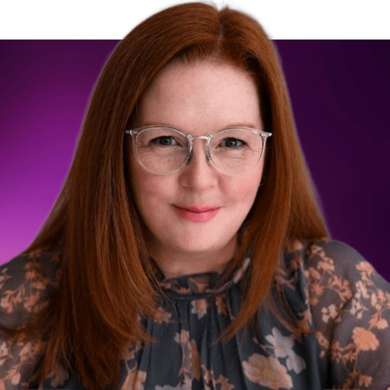 A colleague wearing glasses and a top with flowers smiling.