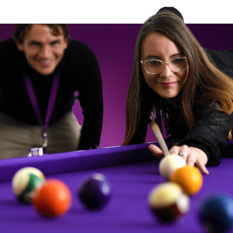 Colleagues playing a game of pool.