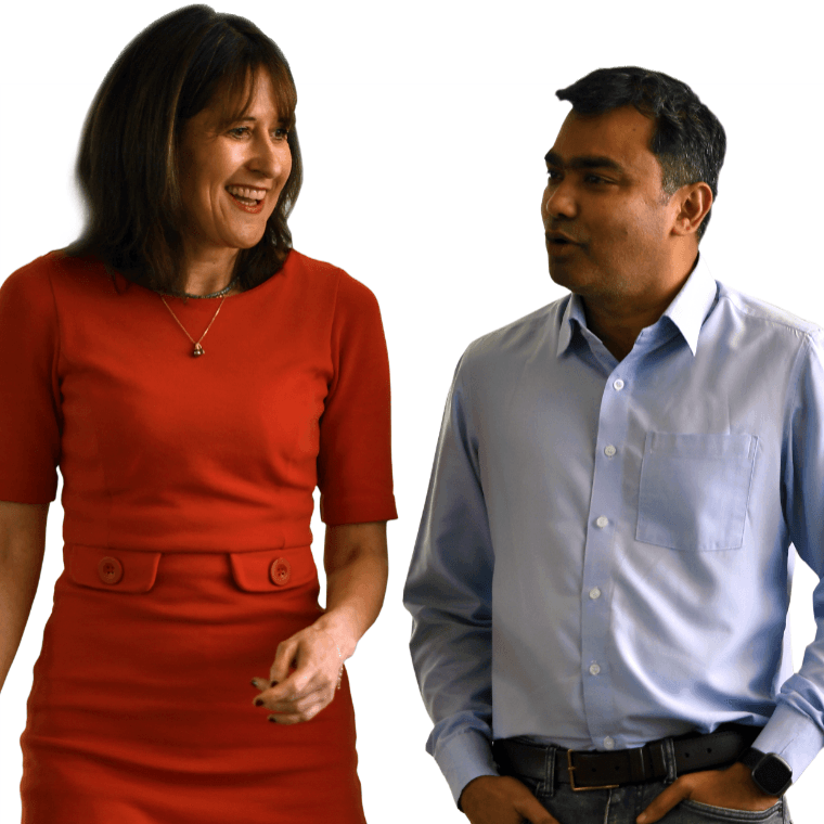 Two colleagues walking together and smiling.