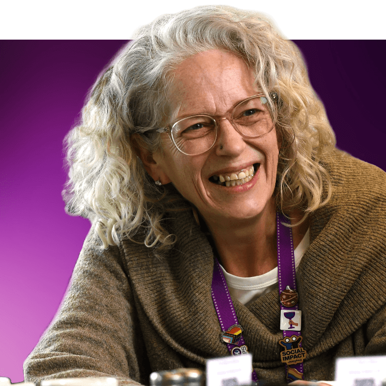 A colleague smiling over a table with hot drinks.