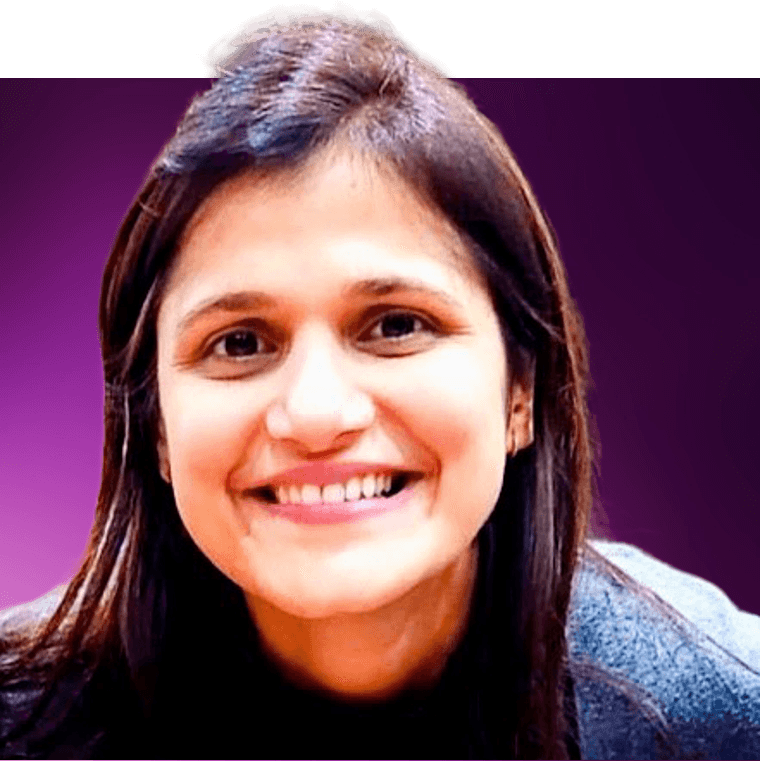 A colleague with dark brown hair wearing a blue cardigan. They are smiling.