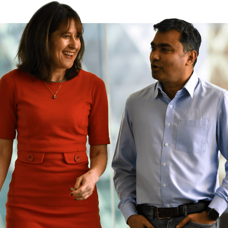Two colleagues walking together and smiling.