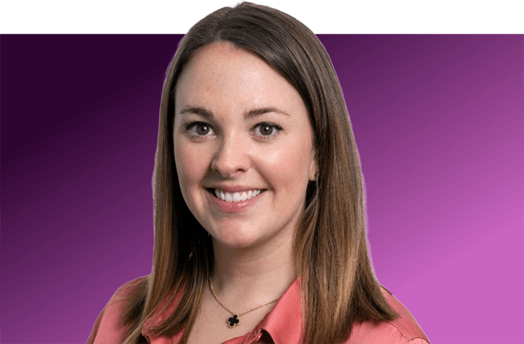 A woman in front of a purple background smiling.