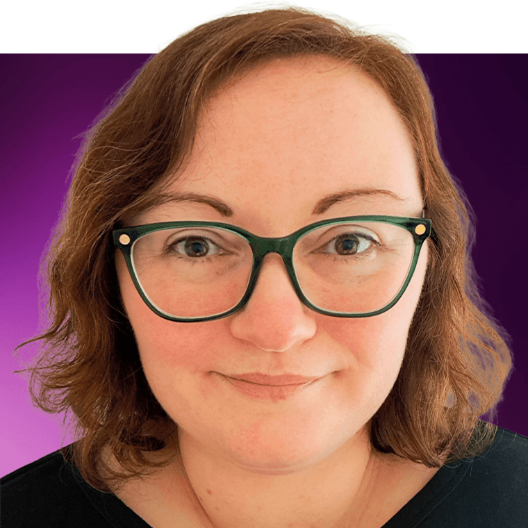 A colleague with red brown hair wearing glasses, smiling.