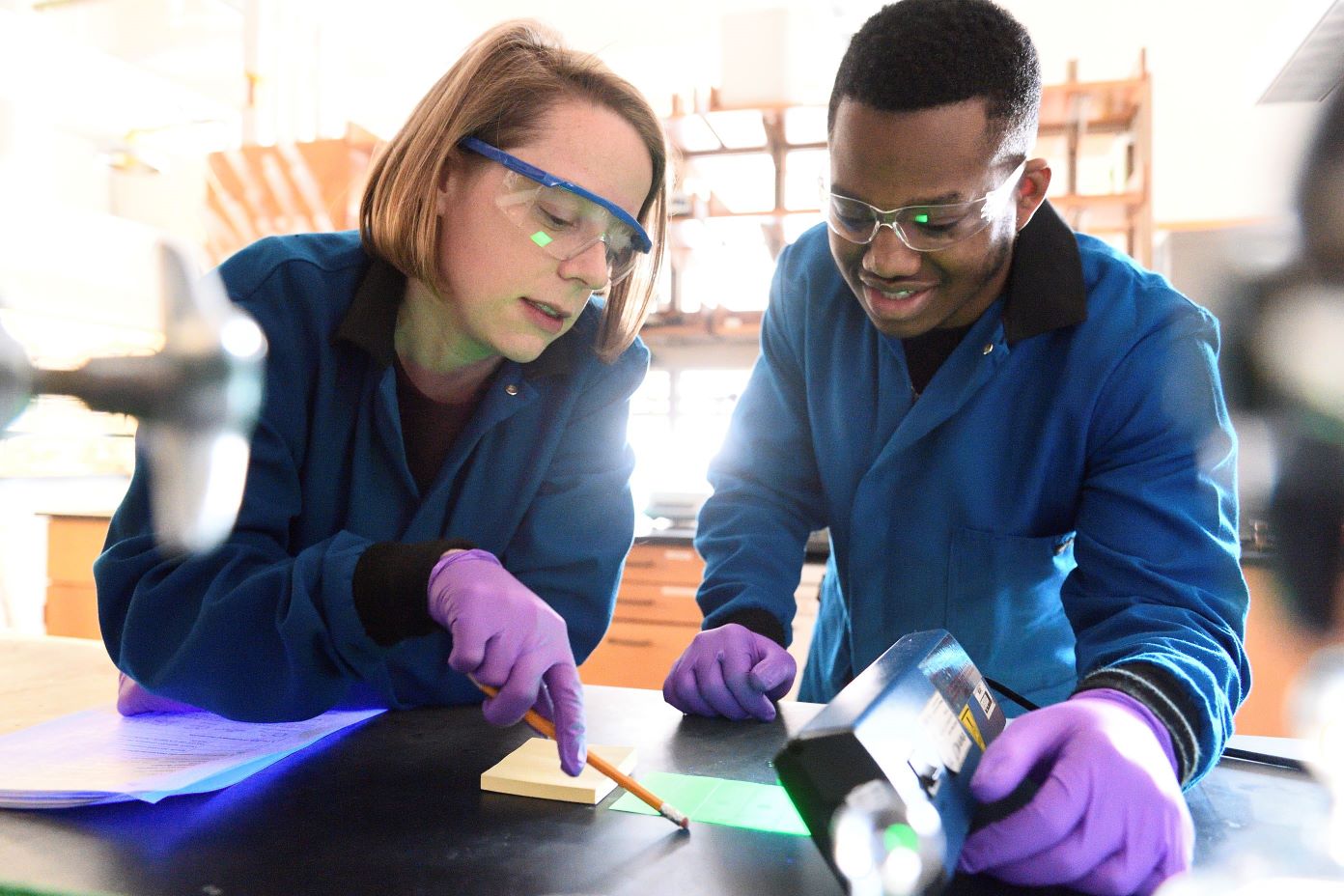 Two people in lab coats discuss Science