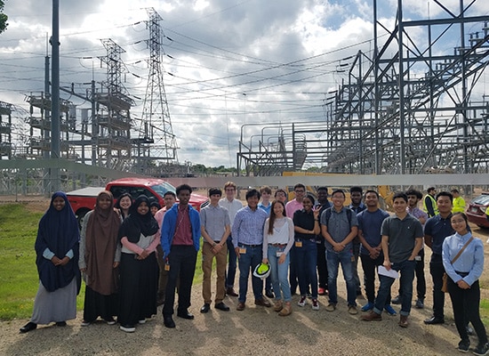 Group of interns at a substation tour posing for a picture