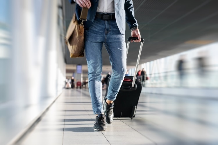 man's legs walking in airport departure area